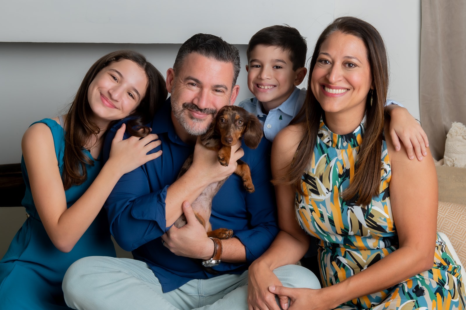 Daniel Santos with his wife Tania and their two children, Alessandra and Duke, holding their dachshund puppy Dixie.