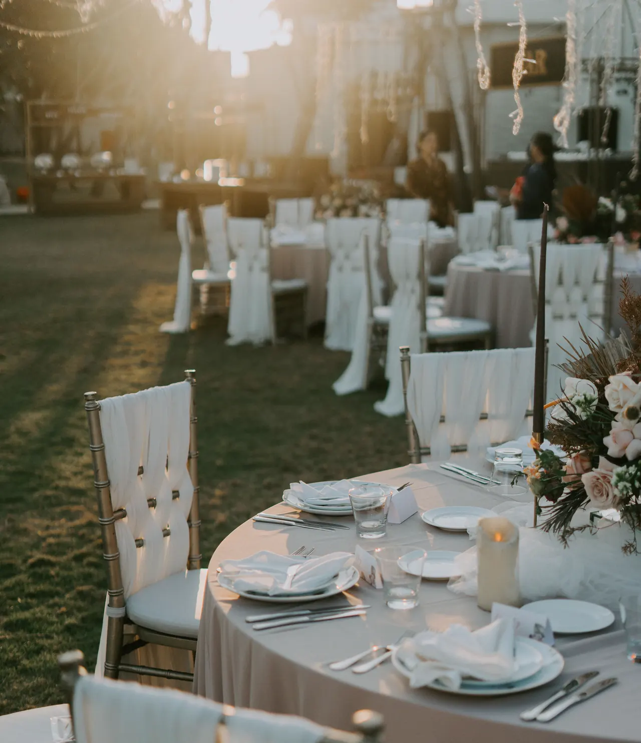 Reception tables set outdoors at sunset.