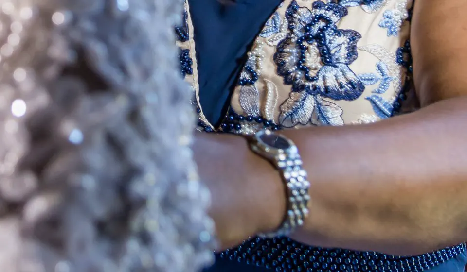 A mother's hands at her daughter's beaded wedding gown.